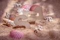 The word `sea` on the sand from wooden letters. Beautiful background with pink seashells and corals. Summer warm atmosphere. Royalty Free Stock Photo