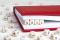Word Sell written in wooden blocks in red notebook on white wood