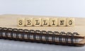 Word SELLING made with letters on wooden blocks on wooden notepad