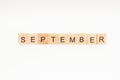 Word SEPTEMBER made of wooden blocks on white background. Month of year. First month of autumn