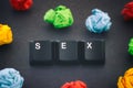 The word Sex on a black background with some colorful crumpled paper balls around it Royalty Free Stock Photo