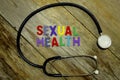 Word SEXUAL HEALTH colorful wooden alphabet letters set and stethoscope on wooden background. Healthcare and medical concept Royalty Free Stock Photo