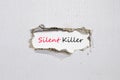 The word silent killer appearing behind torn paper