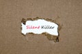 The word silent killer appearing behind torn paper