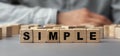 The word SIMPLE made from wooden cubes. Selective focus