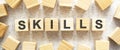 The word SKILLS consists of wooden cubes with letters, top view on a light background