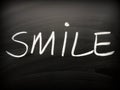 The word SMILE written on a Blackboard