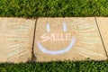 The word `Smile` written with sidewalk chalk