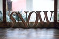 Word SNOW - wooden letters on windowsill and Christmas tree stick behind window Royalty Free Stock Photo