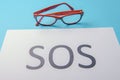Word SOS written on paper