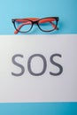 Word SOS written on paper