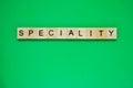 Word speciality. Top view of wooden blocks with letters on green surface Royalty Free Stock Photo