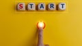 The word start on wooden cubes with a hand pressing the start button. To make a new start in life, business, education, or career Royalty Free Stock Photo