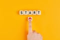 The word start on wooden cubes with a male hand pressing the start button. To make a new start in life, business, education or Royalty Free Stock Photo