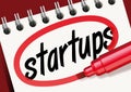 The word startups written in red and surrounded on a notepad
