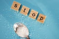 Word STOP made of wooden letters and rafinated sugar on blue background. Royalty Free Stock Photo