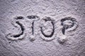 Word Stop written in white flour powder. Concepts of drug abuse as people turn to narcotics abuse during the hard times of covid