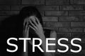 Word STRESS and crying young woman near wall Royalty Free Stock Photo