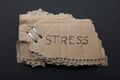 The word `stress` on a torn piece of cardboard box on a black background/ Royalty Free Stock Photo