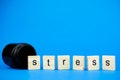 The word STRESS on wooden cubes and a medical dark flask on a blue background. Medical concept on anti-stress Royalty Free Stock Photo