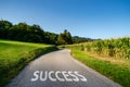 Word Success painted on the road in white colour, concept for direction to success Royalty Free Stock Photo
