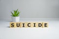 word suicide text spelled on wooden cubes, on white background