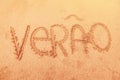 Word `summer` written in portuguese on sand Royalty Free Stock Photo