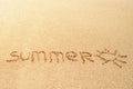 Word SUMMER written in the sand on a beach with drawing of the sun Royalty Free Stock Photo