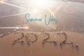 The word summer 2022 written in sea sand. Warm sunset time, vacation and enjoyment Royalty Free Stock Photo