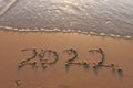 The word summer 2022 written in sea sand. Warm sunset time, vacation and enjoyment Royalty Free Stock Photo