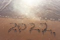 The word summer 2022 written in sea sand. Warm sunset time, vacation and enjoyment Royalty Free Stock Photo