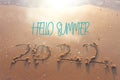 The word summer 2022 written in sea sand. Warm sunset time, vacation and enjoyment Royalty Free Stock Photo