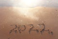 The word summer 2022 written in sea sand. Warm sunset time, vacation and enjoyment Royalty Free Stock Photo