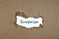 The word surprise appearing behind torn paper
