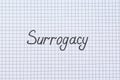 Word Surrogacy written on checkered paper, top view