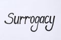 Word Surrogacy written on white background, top view