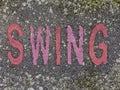 The word SWING on the floor in a kids park