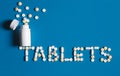 Word tablets is lined with white pills on a blue background, top view