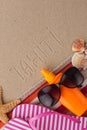 Word TAHITI written in sand with beach accessories