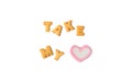 The Word TAKE MY HEART spelled with alphabet shaped cookies and a heart shaped marshmallow candy on white background