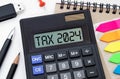 Word Tax 2024 on the calculator. Business and tax concept. alculator, coins, book, form, and pen on table Royalty Free Stock Photo