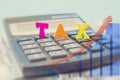 The word `tax` from colored letters on a calculator and business graph. Close-up. Financial concept. Digital editing .Selective fo