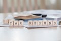 Word TAX REFUND is composed of wooden letters.