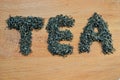 Word tea made from loose leaf tea on wooden background