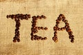 Word `Tea` Written In Coffee Beans Over Bagging Background. Coffee Beans Background. Royalty Free Stock Photo