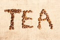 Word `Tea` Written In Coffee Beans Over Bagging Background. Coffee Beans Background. Royalty Free Stock Photo