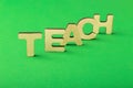 Teach word inscription, wooden letters on green background