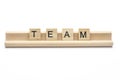 Word ``team`` on scrabble wooden letters on a rack, isolated on Royalty Free Stock Photo