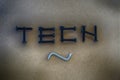 The word TECH by screws on a black-gray background.