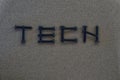 The word TECH by screws on a black-gray background.